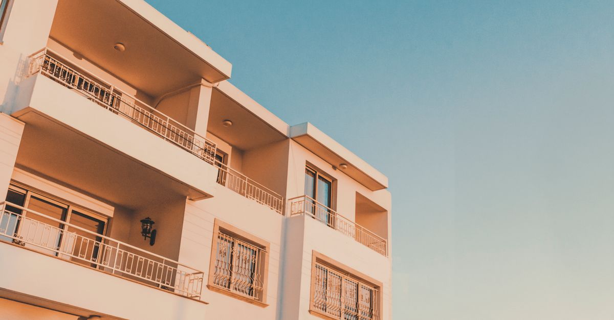 A modern apartment building with balconies in Paphos, Cyprus, captured during a vibrant sunset.